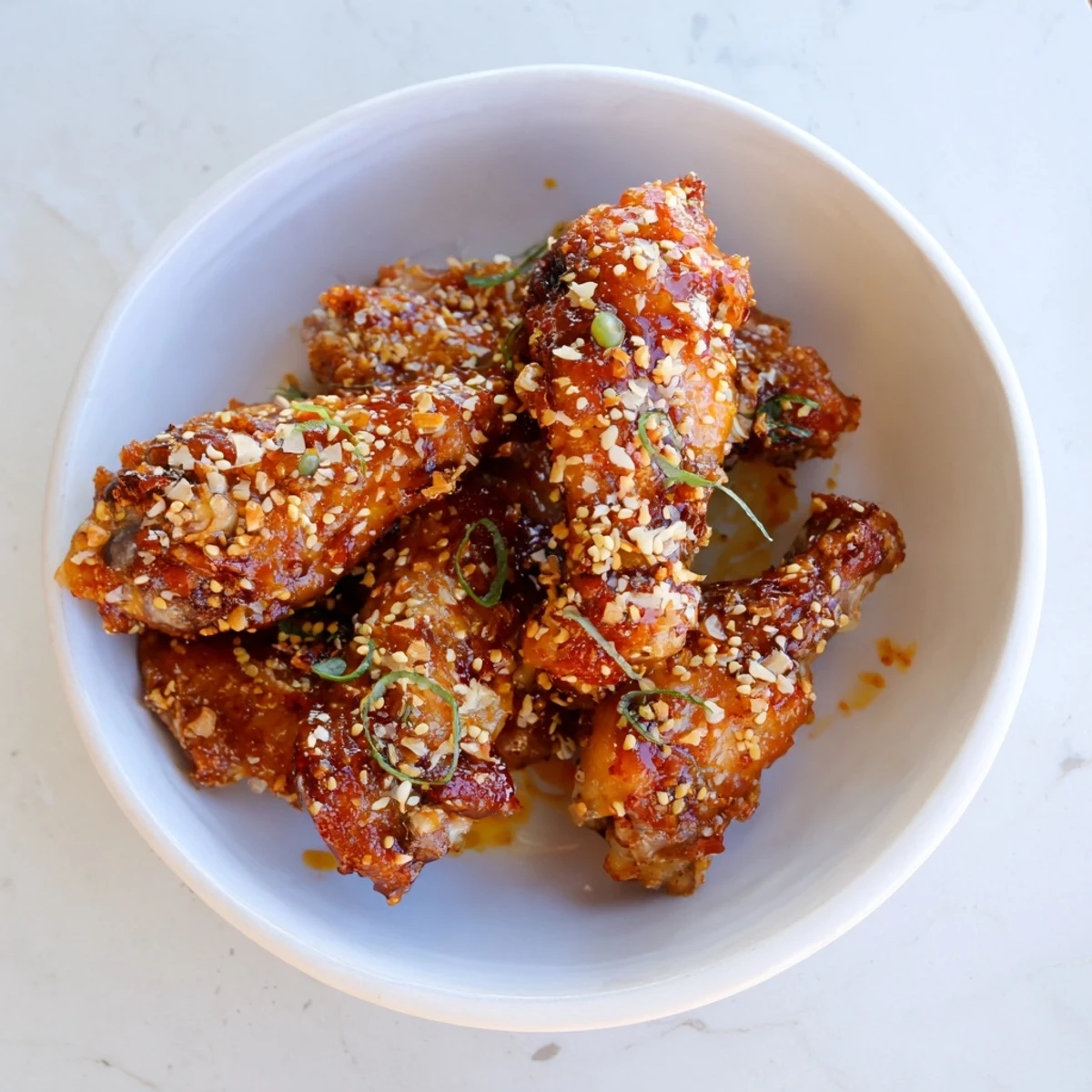 Golden-brown Crispy Honey-Chili Glazed Chicken Wings, glazed and ready to serve, a perfect appetizer.