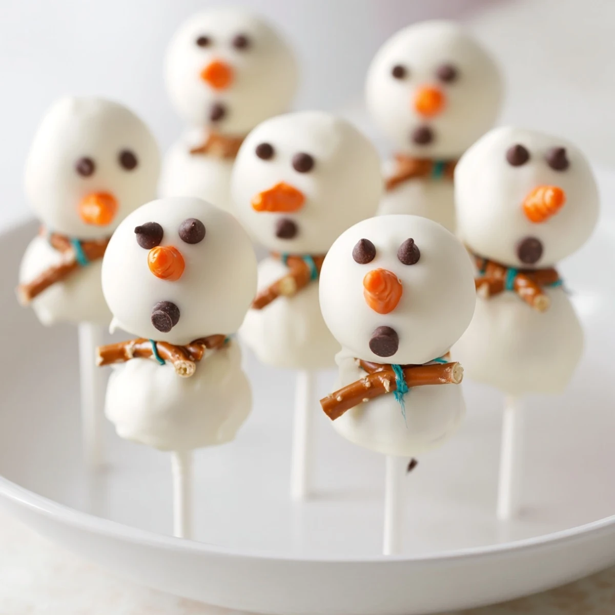 Oreo Snowman Cake Pops, coated in white chocolate, ready to be decorated with festive faces.