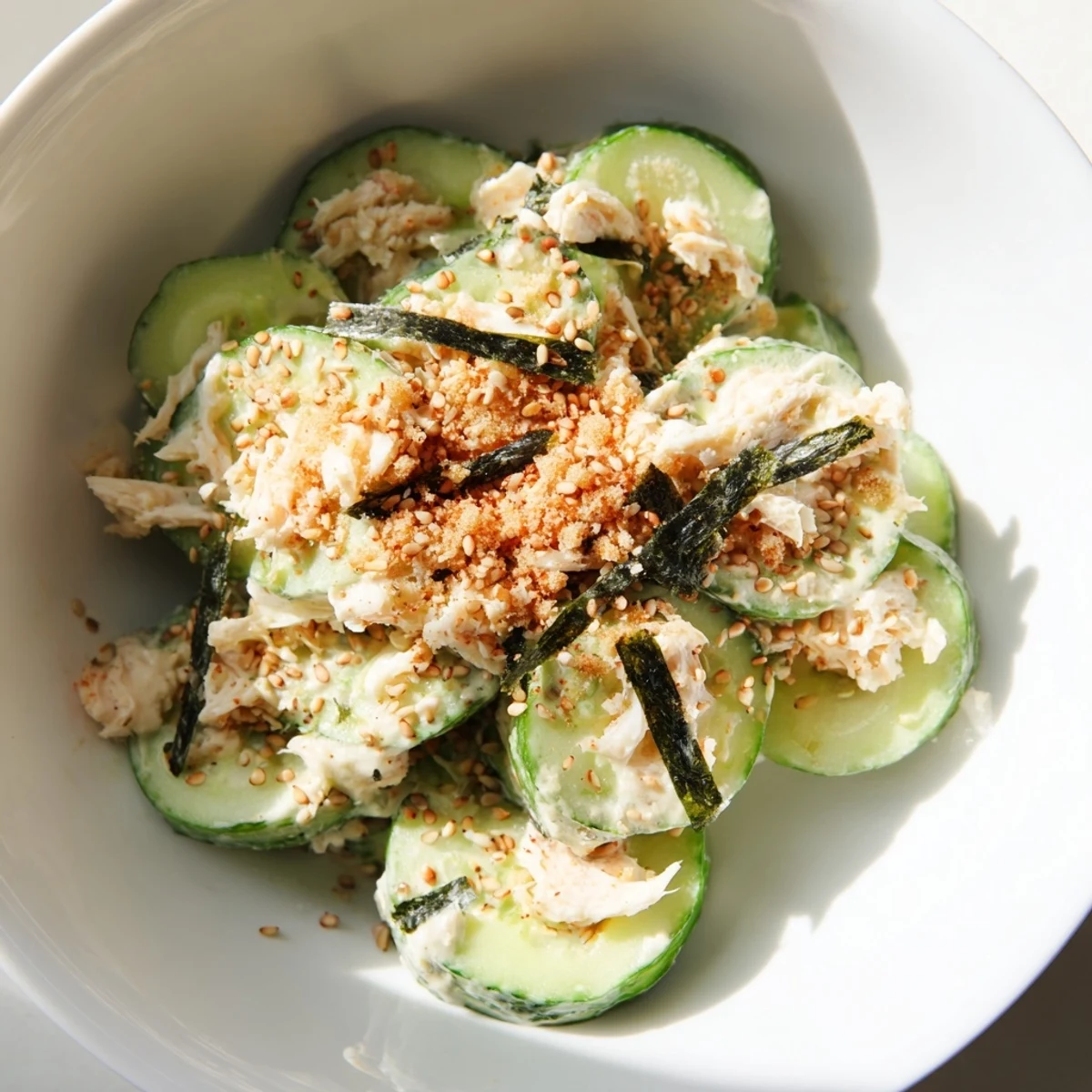 Vibrant California Roll Cucumber Salad featuring crisp cucumbers, creamy dressing, and sesame garnish, ready to enjoy immediately.