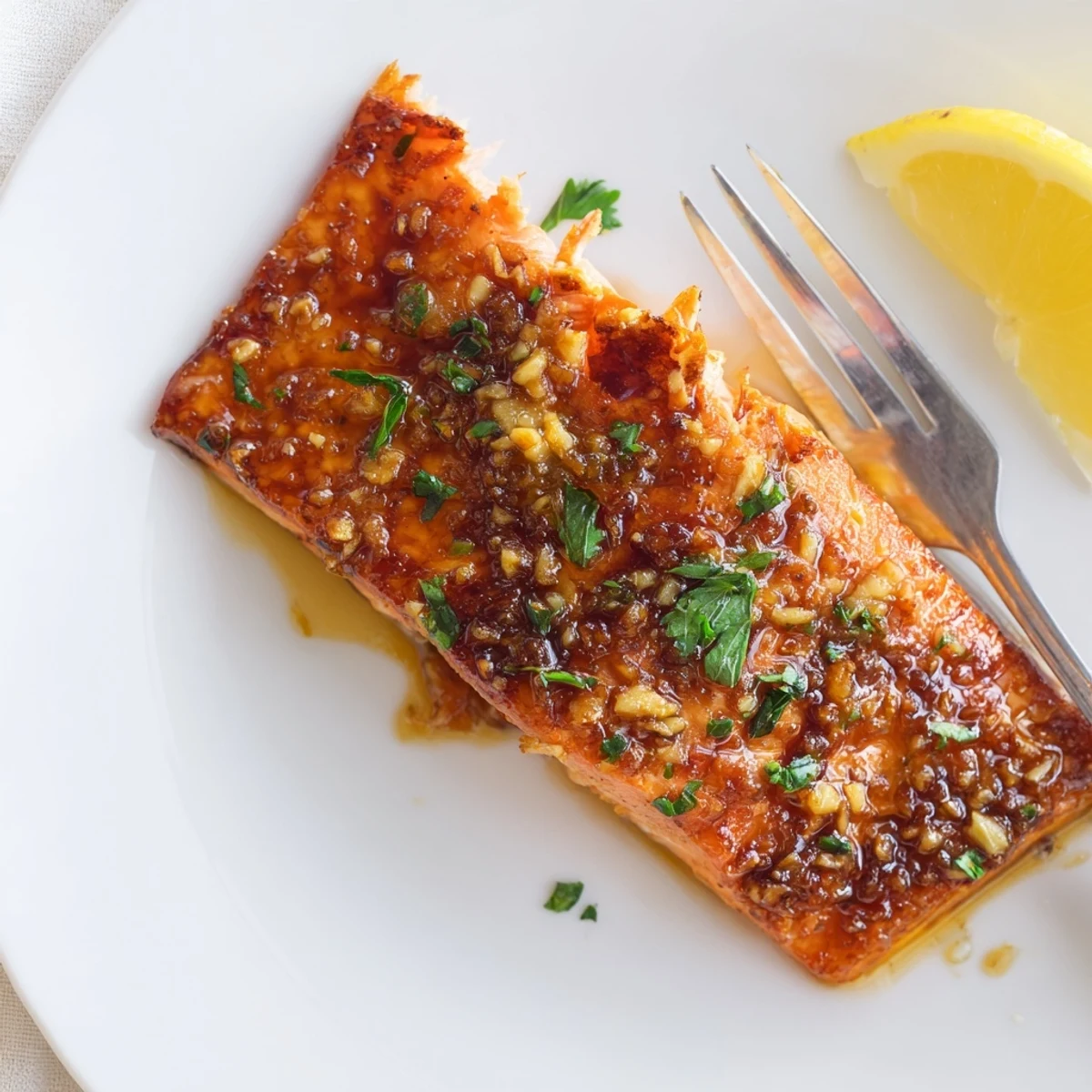 Golden-brown Honey Garlic Glazed Salmon fillets roasted until caramelized and served with fresh lemon wedges and parsley.  