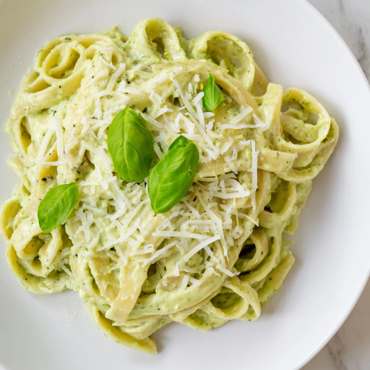 Serve Creamy Green Pea Alfredo from a rustic white bowl, topped with grated Parmesan and cracked black pepper for extra flavor.
