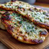 Serving suggestion: Soft, fluffy Easy Garlic Naan Bread alongside a steaming bowl of homemade curry for a complete Indian meal.