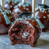 Festive graduation cake pops featuring school colors, chocolate coating, and fondant cap decorations for a memorable dessert.  