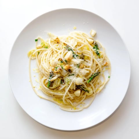 A plate of Roasted Garlic & Asparagus Pasta with al dente spaghetti, tender green asparagus, and mashed roasted garlic in olive oil. 