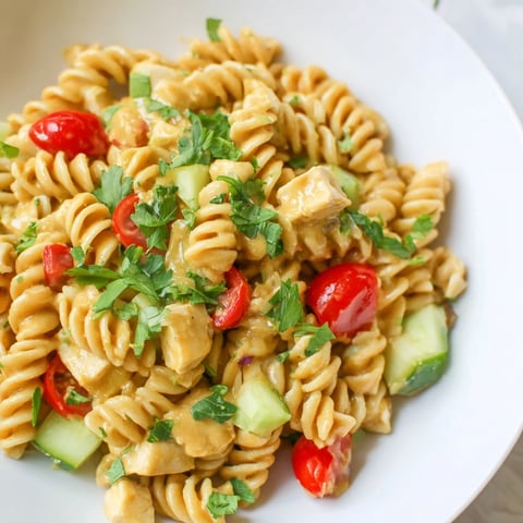 Close-up of Honey Mustard Chicken Pasta Salad with shiny dressing and diced chicken
