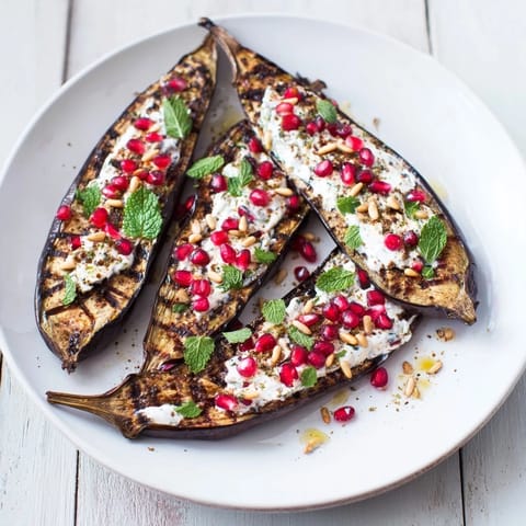 Tender, roasted eggplant halves drizzled with tangy yogurt, a beautiful vegetarian meal with fresh garnishes.