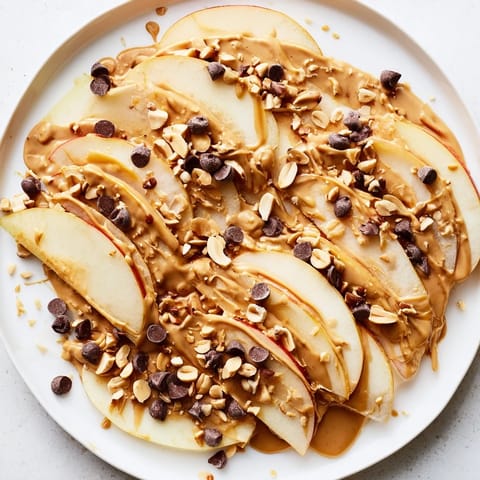 Sweet and savory Peanut Butter Apple Nachos: Delightful snack featuring drizzled peanut butter on fresh apples.