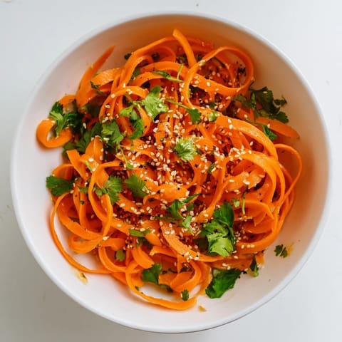 Tossed carrots in savory soy-sesame dressing create a refreshing, crunchy side dish for any meal.