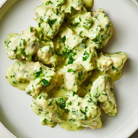 Bright, herb-packed Green Goddess Chicken Salad with sliced cucumber, juicy tomatoes, and a refreshing yogurt-based dressing on crisp greens.