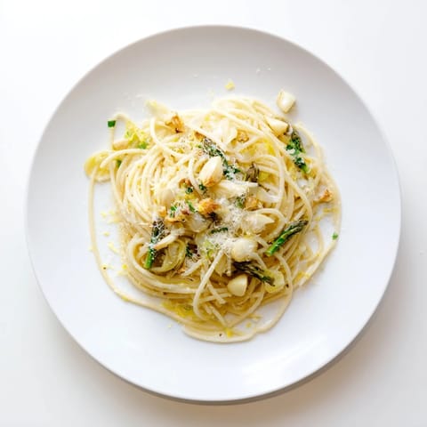 A plate of Roasted Garlic & Asparagus Pasta with al dente spaghetti, tender green asparagus, and mashed roasted garlic in olive oil. 