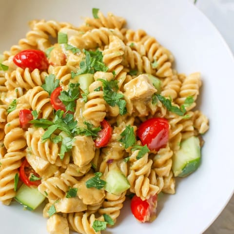 Close-up of Honey Mustard Chicken Pasta Salad with shiny dressing and diced chicken
