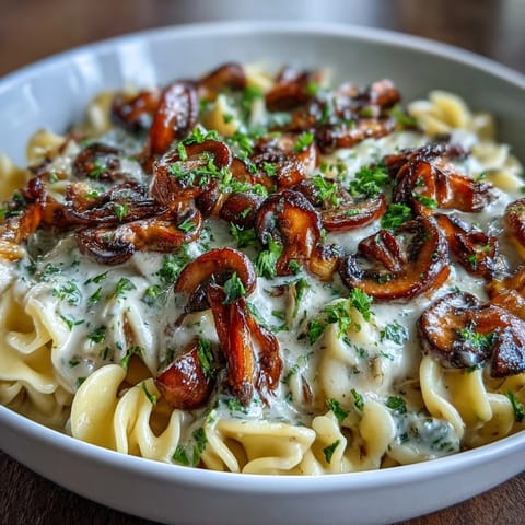 Creamy onion and mushroom stroganoff served over tender egg noodles with a rich, savory sauce.  