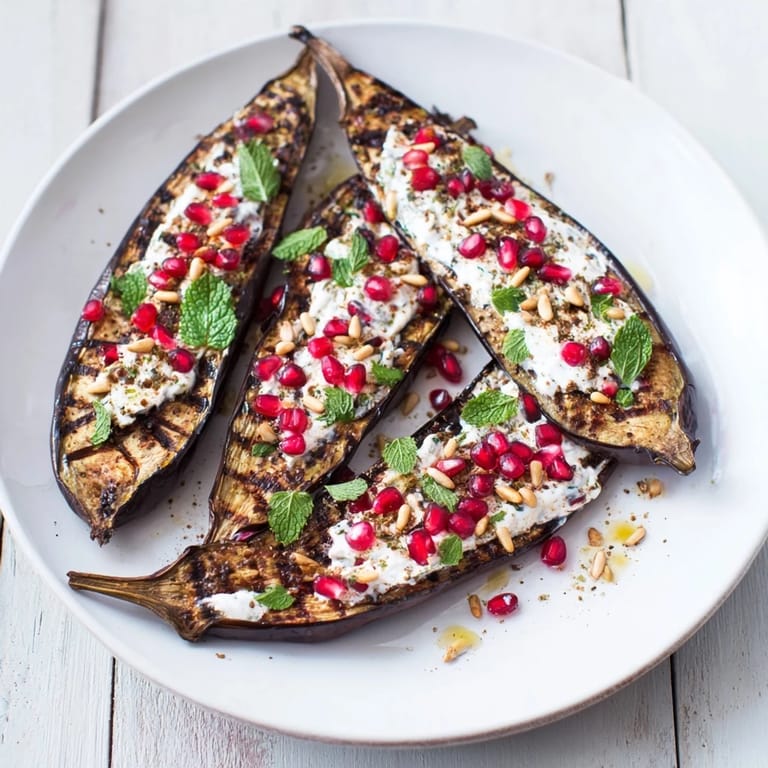 Tender, roasted eggplant halves drizzled with tangy yogurt, a beautiful vegetarian meal with fresh garnishes.