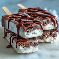 Creamy vanilla bean frappuccino fudge pops with swirls of rich chocolate, perfect for a cool summer treat.